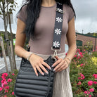 woman wearing the printed flower bag strap in black with white flowers