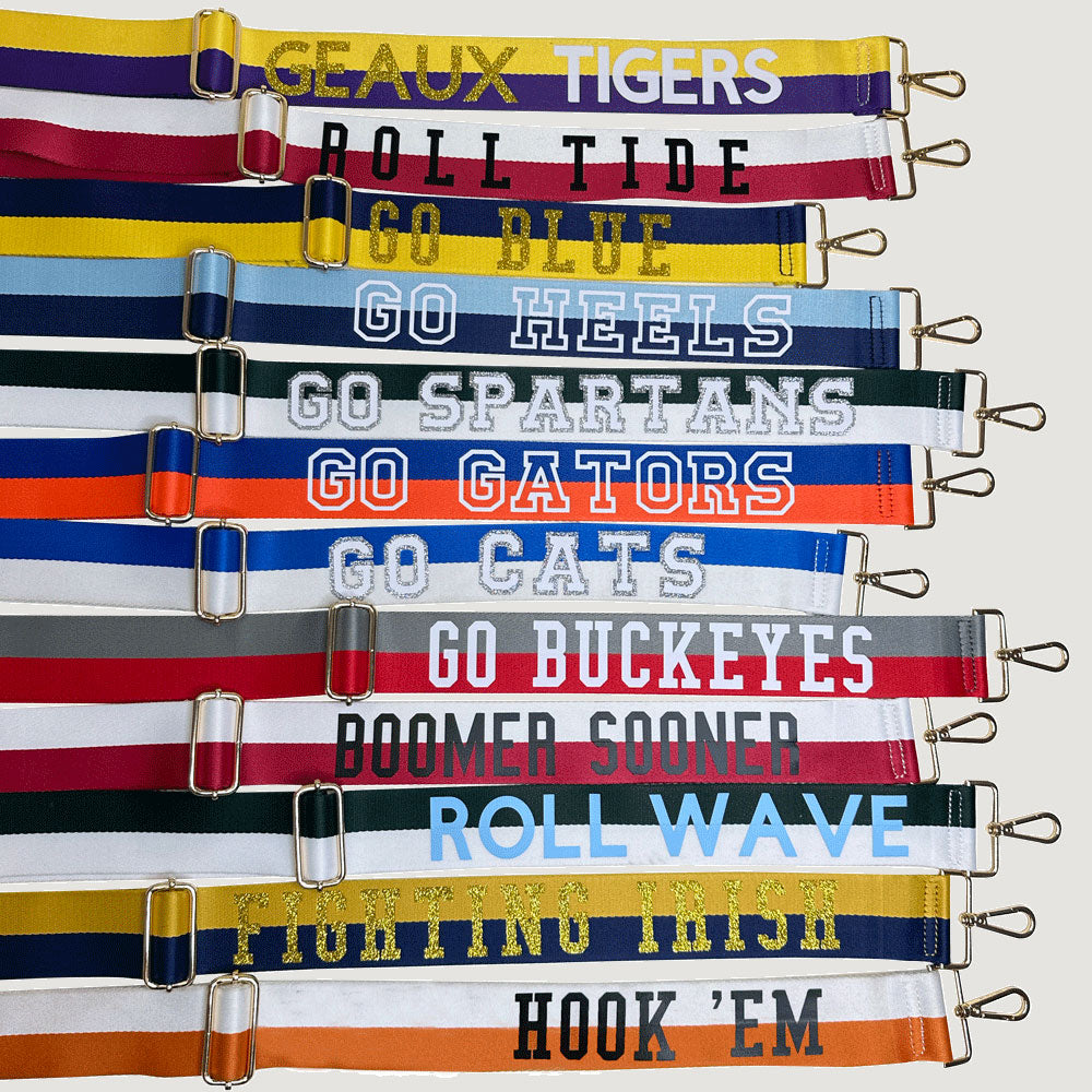 Group of Custom Game Day Bag Straps, text on straps say "Geaux Tigers, Roll Tide, Go Blue, Go Heels, Go Spartans, Go Gators, Go Cats, Go Buckeyes, Boomer Sooner, Roll Wave, Fighting Irish, Hook 'Em"