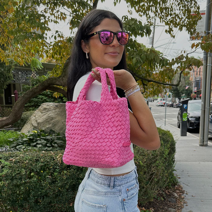 Woman holding the Linda Woven Velour Tote bag in Pink over her back shoulder. 