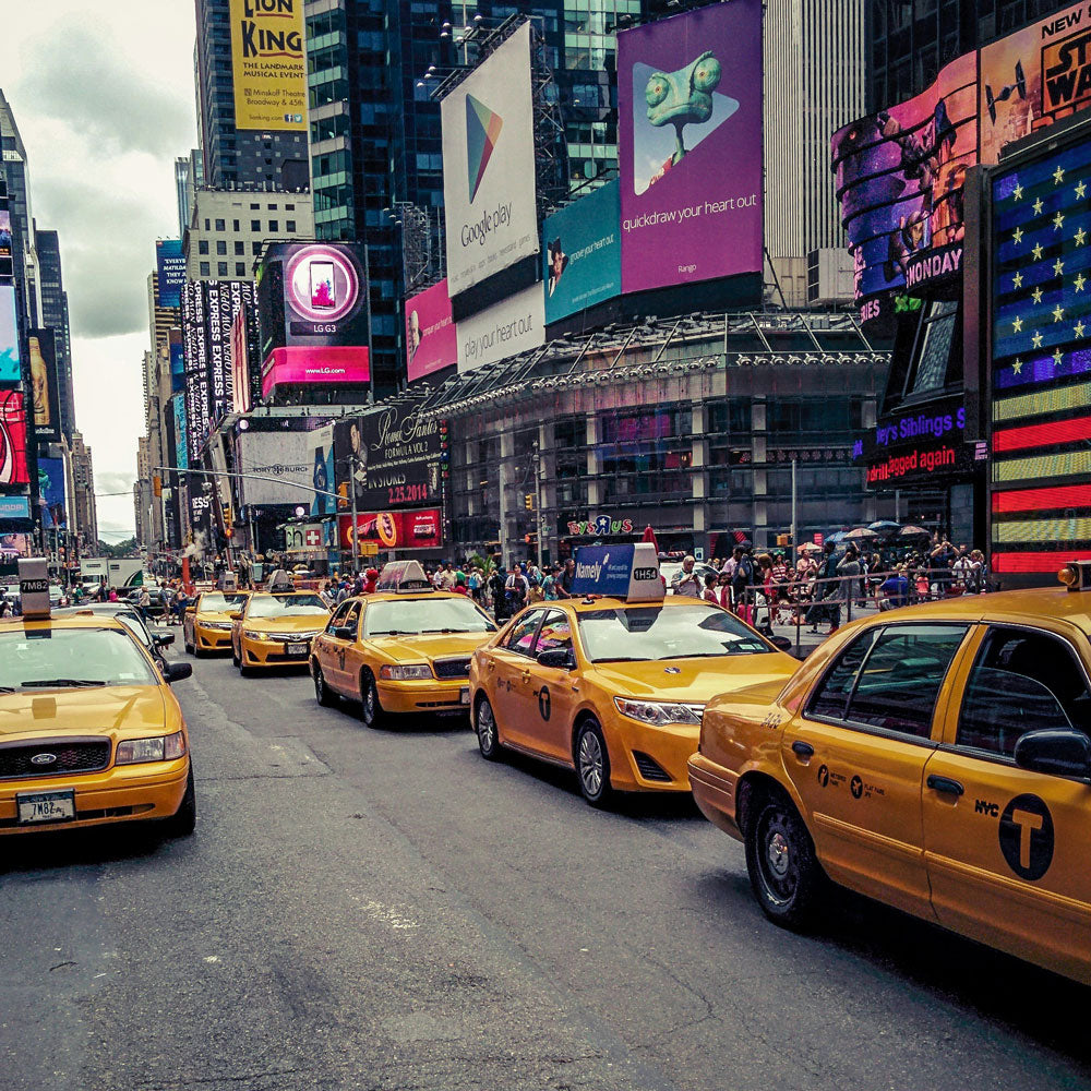 Image of a busy street in NY with Building and Taxi Cabs. 