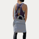 woman wearing the nicole tote in grey as a crossbody