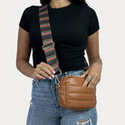 women wearing the Sadie Quilted Vegan Leather Crossbody in Camel with a Multi Striped Bag Strap